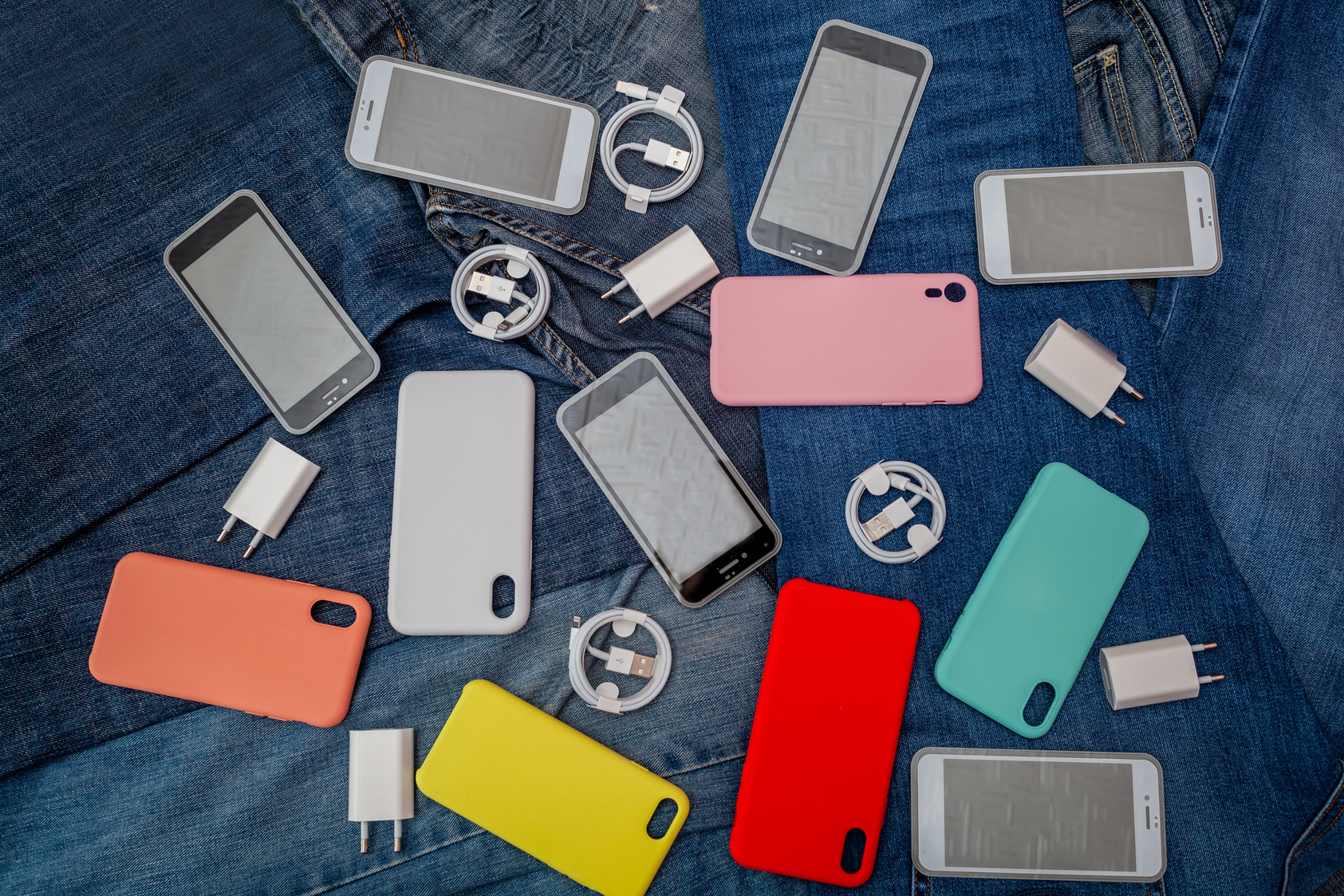 Cellphones and Accessories Scattered on Denim Jeans Fabric 